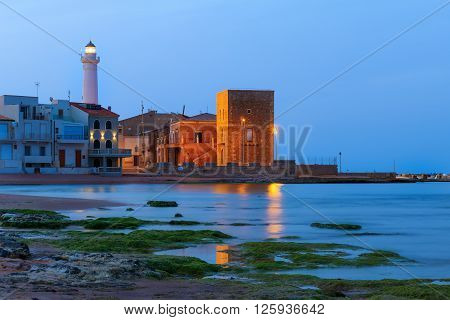 Dawn at Punta Secca Beach with the lighthouse and the watchtowerTorre Scalambri in Santa Croce Camerina Sicily Italy