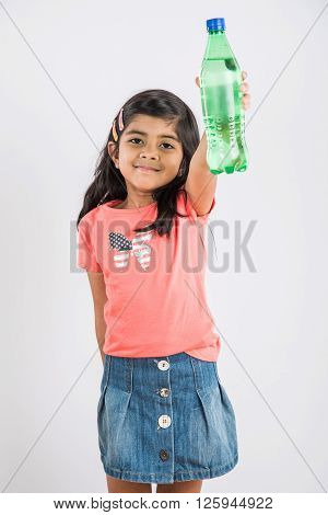 indian girl with cold drink bottle, asian girl drinking cold drink in pet bottle, girl kid and cold drink, indian cute girl with lemon or transparent juice in plastic bottle, isolated on white