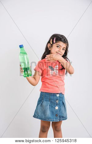indian girl with cold drink bottle, asian girl drinking cold drink in pet bottle, girl kid and cold drink, indian cute girl with lemon or transparent juice in plastic bottle, isolated on white