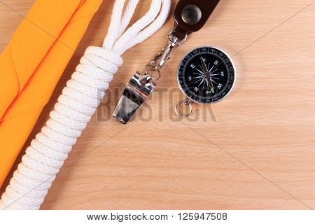 Orderliness White Scout Rope, Scarf, Whistle And Compass On Wooden Table.