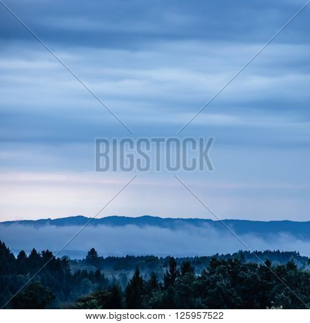 foggy hilly ground in front of a mountain chain with blue moving clouds
** Note: Visible grain at 100%, best at smaller sizes
