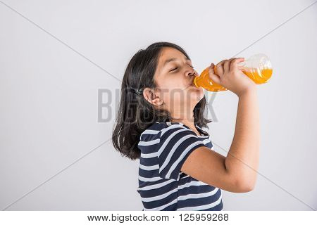 indian girl with cold drink bottle, asian girl drinking cold drink in pet bottle, girl kid and cold drink, indian cute girl drinking mango juice or orange juice in plastic bottle