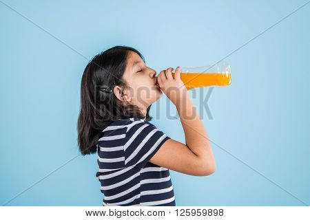 indian girl with cold drink bottle, asian girl drinking cold drink in pet bottle, girl kid and cold drink, indian cute girl drinking mango juice or orange juice in plastic bottle