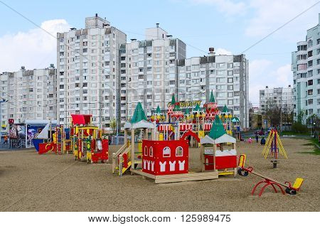 GOMEL BELARUS - APRIL 14 2016: Unidentified parents play with a child on a modern children's playground on the street Khatayevich Gomel Belarus