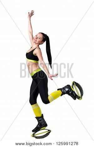 Smiling athletic brunette girl with a long hair jumping in a kangoo jumps shoes. isolated on a white background.