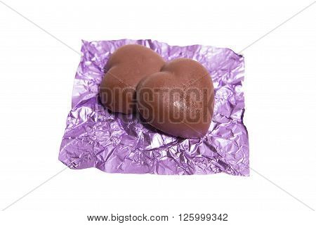 Two chocolate heart candy in puple foil on white background