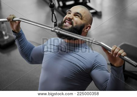 Emotions of professional athlete pulling down heavy weight, sports training