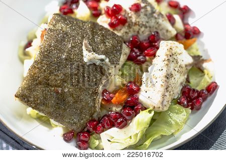 Skrei winter cod with skin roasted on braised pointed cabbage with pomegranate seeds