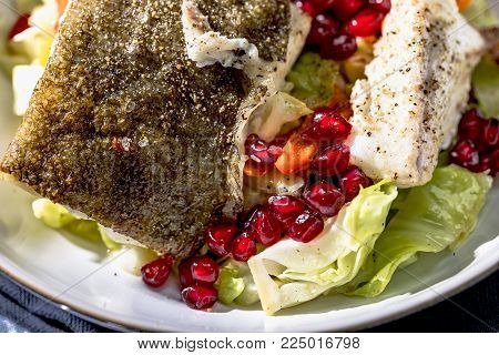 Skrei winter cod with skin roasted on braised pointed cabbage with pomegranate seeds