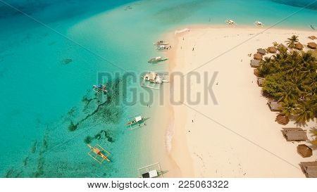 Aerial view of beautiful tropical island Daco with white sand beach. View of a nice tropical beach from the air. Beautiful sky, sea, resort. Seascape: Ocean and beautiful beach paradise. Philippines. Travel concept.