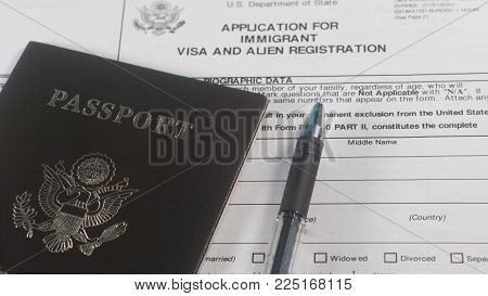 Application for immigrant visa and Alien Registration form and passport with pen