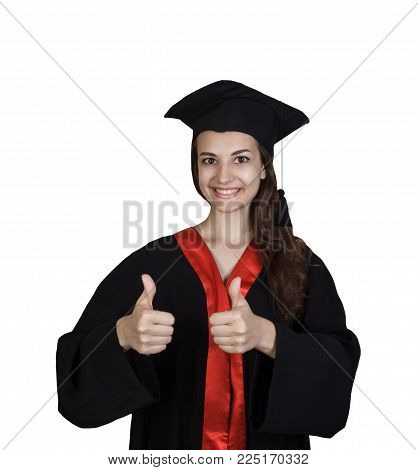 Smiling young woman in graduation gown showing thumbs up.