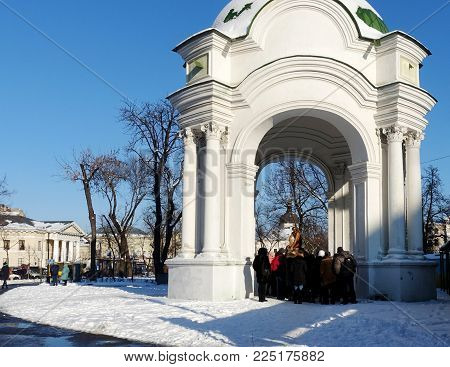 Kiev, Ukraine - January 20, 2018 Tourists view the Samson fountain sculpture in Kiev on Kontraktova Square. Winter day