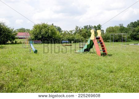 A Childrens Playground. Swing, Carousel And Slide