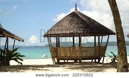 Beach with white sand with beach house on a tropical island Daco. Beautiful sky, sea, resort. Seascape: Ocean and beautiful beach paradise. Philippines. Travel concept.
