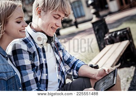 Modern Igen. Joyful Young Nice People Sitting Together And Looking At The Tablet Screen While Using 