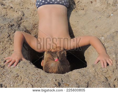 Little Kid Playing In The Sand On The Beach