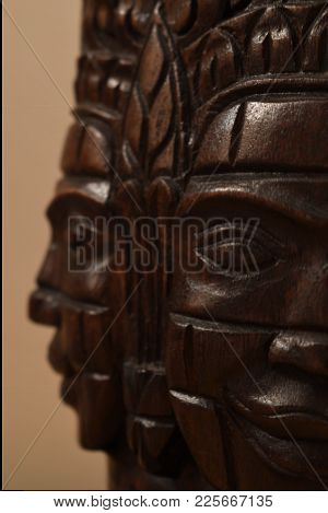 Closeup Of A Wooden Mask Sculpture From Cambodia, Showing Two Faces Looking Perpendicular To Each Ot