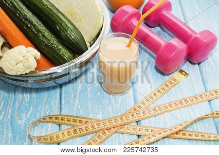Glasses With Fresh Vegetable Juices And Dumbbells On Table