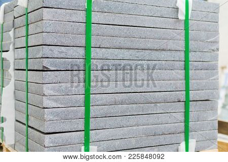 Complex Granite Slabs Packed By Plastic Stripes On Wooden Pallet. Selective Focus