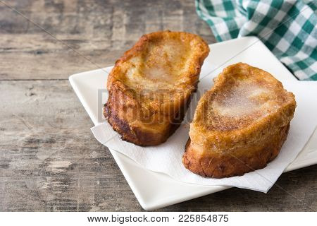 Traditional homemade Spanish torrijas on wooden background. Easter dessert.