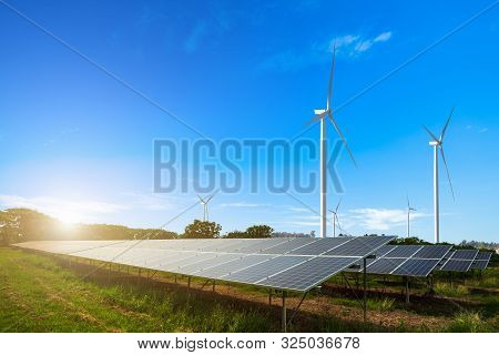 Solar Panels With Wind Turbines Against Mountanis Landscape Against Blue Sky With Clouds,alternative