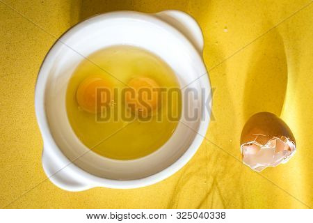 Egg Yolks With Egg Shells And Whisk On Yellow Silestone