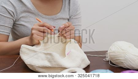 Woman knitter making fabric from thread