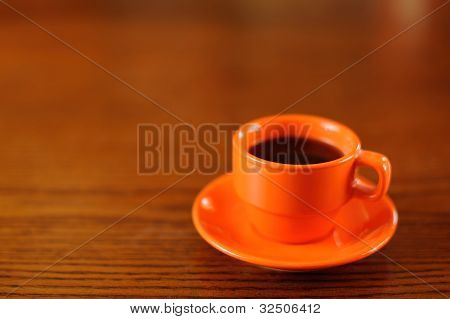 Arancia tazza di caffè sul tavolo di legno