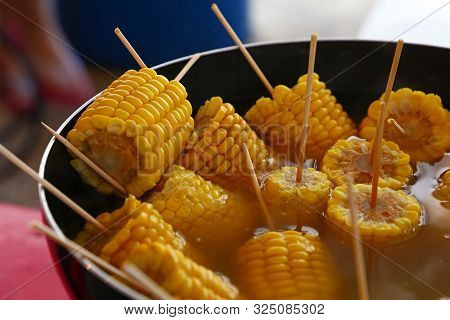 Closeup Ready To Eat Boiled Or Steamed Sweet Corn Cobs On Stick In A Big Cooking Pan, High Angle Vie