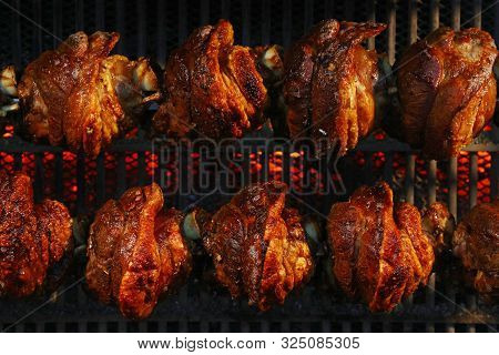 Several Traditional Bavarian German Roasted Pork Knuckles Slowly Cooked At Rotating Broiling Rack Gr
