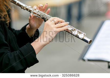 A Closeup Plane Of Street Orchestra Flautist With Flute In Her Hands