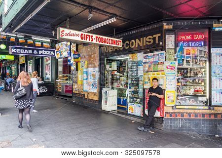 Sydney, Australia - 15th March 2013: A Young Man Lounges Against A Tobacconists Shop On A Corner Of 