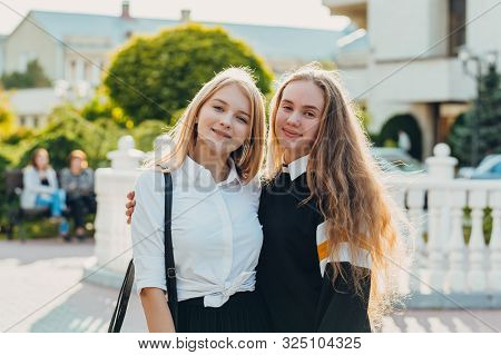 Happy Brightful Positive Moments Of Two Stylish Girls Hugging On Street In City. Closeup Portrait Fu