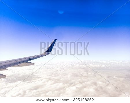 Wing Of The Plane On Blue Sky Background .  Airplane Wing In Flight From Window, Blue Sky . Travel C