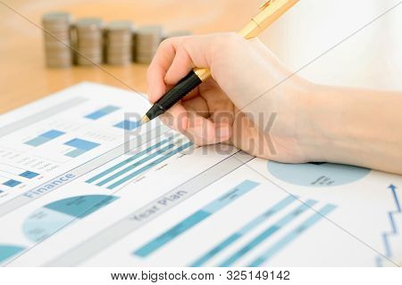 A Businesswoman Analyzing Financial Graph With Coins