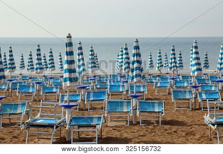 Many Sun Umbrellas And Deckchairs  On The Sandy Beach Of The Resort In Summer