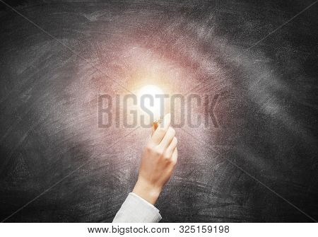 Human Hand With Glowing Incandescent Lamp On Background Grunge Wall. Professional Business Assistanc