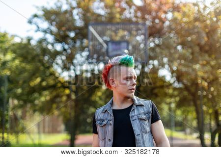 Portrait of a cool young man with pink mohawk
