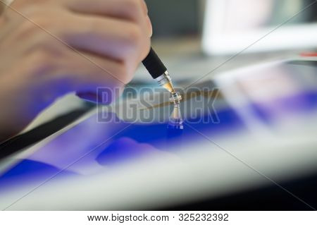 A Person Drawing Something On A Tablet.