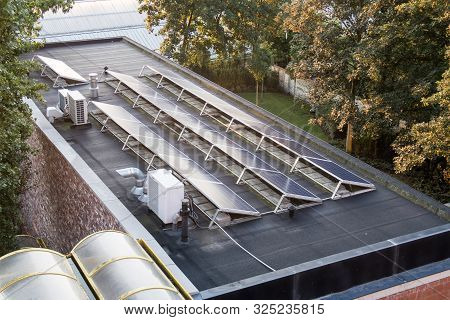 In The City, These Solar Panels Are Located On A Flat Roof Of A Large Building