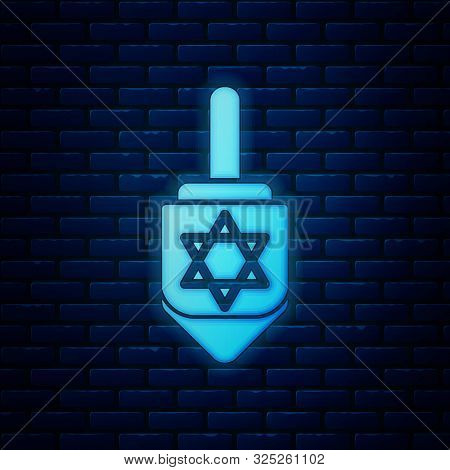 Glowing Neon Hanukkah Dreidel Icon Isolated On Brick Wall Background. Vector Illustration