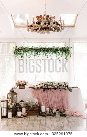 Lights, Wooden Parts And White Candles Stand On A Parquet Near The Groom And Bride Desk