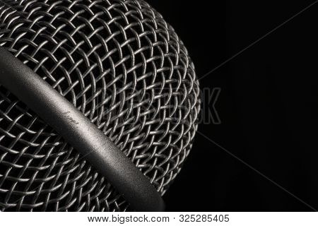 Close-up Black Microphone Head Isolated On Black Background.