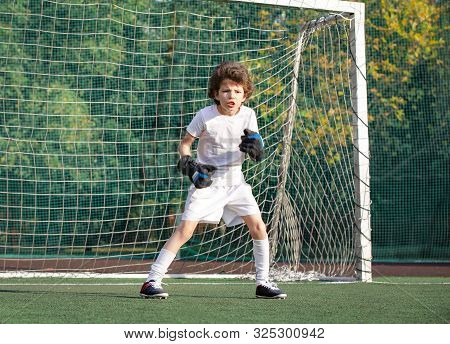 Young Goalkeeper On An Outdoor Court Standing In The Football Gate. Football, Soccer Player. Goalkee