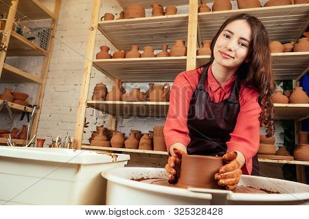 A Portrait Of A Beautiful Woman Potter Molds From A Clay Pot In A Mastre. A Woman Works With Clay On