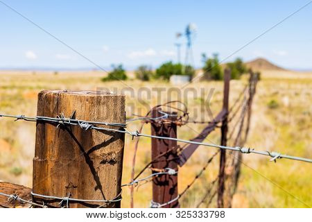 Windmill On A Farm In Rural Grassland Area Of South Africa