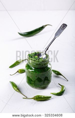 Hot Chili Pepper Paste. Green Sauce In Glass Jar On White Background. Adjika Or Ajika In Georgian Cu