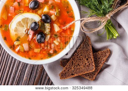 Traditional Russian Meat Soup Solyanka In Bowl On Rustic Wooden Table