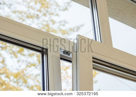 Open Modern Window And Yellow Leaves Outside The Window